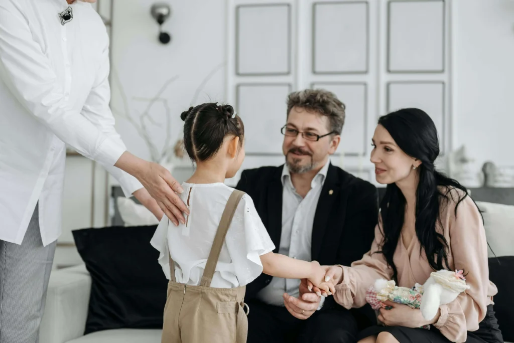 parents smiling and shaking hands with the child